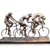 bronze sculpture of three cyclists racing