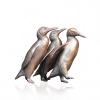 bronze sculpture of a group of penguins walking
