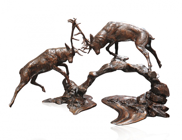 large bronze sculpture of two stags rutting at dawn