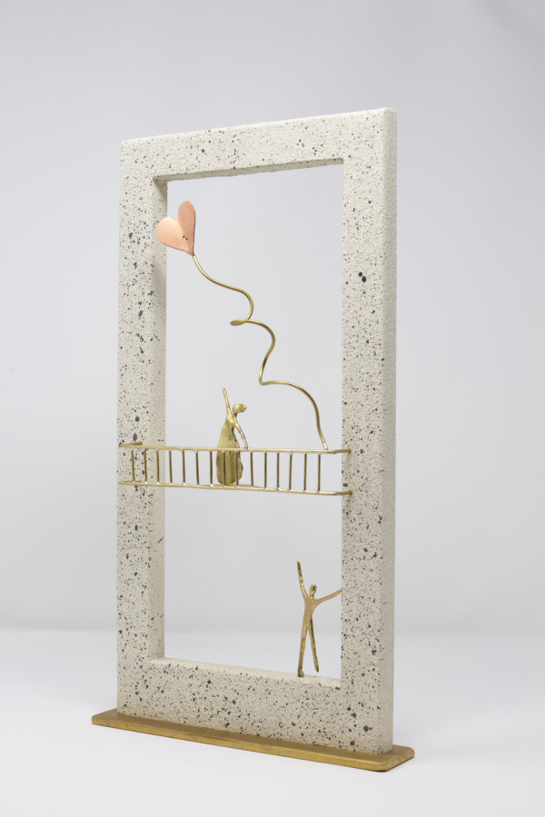 Limited Edition hand made bronze sculpture featuring a couple setting where she is above him on a balcony while he is serenading her and sending her heart shaped balloons her way in a lovely contrasty white frame by Anna Andreadi