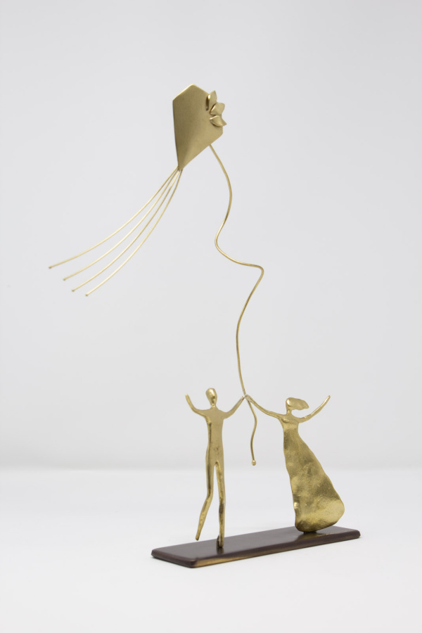 Limited Edition hand made bronze sculpture featuring a couple with their hands up at the same time as holding a kite celebrating by Anna Andreadi