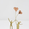 Limited Edition hand made bronze sculpture featuring a couple holding two heart shaped balloons up in the air by Anna Andreadi
