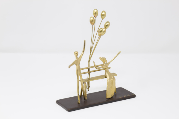Limited Edition bronze sculpture featuring a couple sitting on a bench and celebrating a special occasion with floating balloons by Anna Andreadi