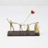 Limited Edition hand made bronze sculpture featuring a family dad, mum, son and daughter holding hands and holding a balloon in heart shape by Anna Andreadi
