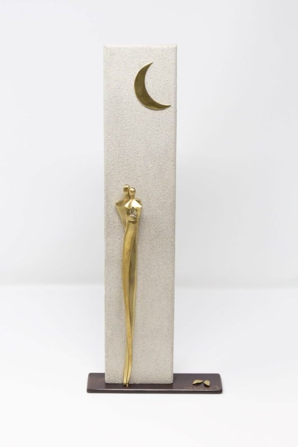 romantic bronze sculpture of two embracing figures set against a textured pillar with a moon above the figures heads by artist anna andreadi