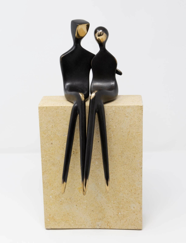 large limited edition bronze sculpture of two statuettes in a minimalist style embracing one another in a romantic pose sat atop a solid stone base finished in a dark black patina with golden polished elements